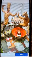 Photo of two large chef statues in orange, and one smaller bartender figurine with assorted kitchen bowls and decor items on a table with chef cloth.