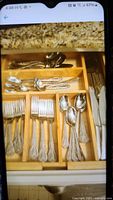 Full view of the wooden divider tray with all silverware inside organized by type
