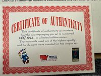 Certificate of Authenticity confirming limited edition pin set number 285 of 1996 and details about material and design quality.