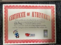 Certificate of authenticity with number 550/1996, border in red, black and white text