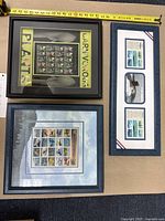 Top view of all three framed stamp collections displaying carnivorous plants, aircraft, and submarines with a measuring tape showing widths.
