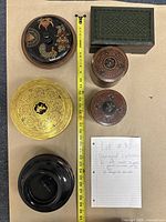 Top view of all 6 decorative containers arranged around a measuring tape and handwritten note describing the lot.