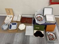 Top view of the complete set including three different ceramic bowls, two lacquer trays, and multiple original storage boxes with some Japanese inscriptions visible.