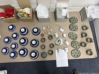 Overhead view of entire tea and sake set including cups, saucers, bowls, and tea pot arranged on the floor