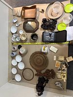 Full view of various household items including ceramics, wooden trays, statues, glass and plastic containers, mineral specimens.