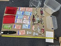 Overview of dolls, packaged items, fabric pouches, umbrella, and plastic container.