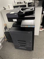 Front view of Kyocera ECOSYS multifunction printer with touchscreen control panel and paper trays