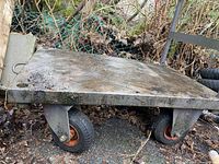 Close-up side view focusing on one swivel caster wheel and underside of steel platform.