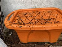 Top view showing the orange plastic water cart surface with non-slip textured pattern and some dirt marks.