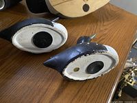 Photo of the undersides of three duck figurines showing felt pads and wear on the paint