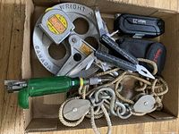 Photo showing all lot items including pulleys, rope, green handheld tool, multitools, and hooks