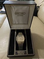 Seiko Quartz watch displayed in its original black and beige branded presentation box with velvet lining.