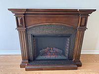Front view of electric fireplace with wooden mantel
