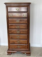 Front view of wooden highboy dresser showing all drawers and hardware.