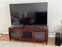 Front view of Hisense TV on wooden stand