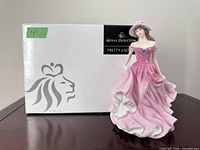 Front view of Royal Doulton figurine in pink dress standing beside original box labeled 'Pretty Ladies'
