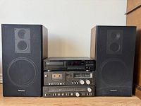 Front view of the stereo system showing the Technics receiver, tape deck, Pioneer CD player, and the two Technics speakers.