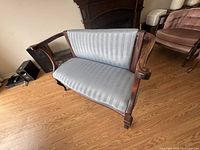 Front angle of settee showing curved arms and upholstery