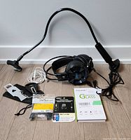 Full lot showing all items including gooseneck phone holder, LVLUP gaming headset, Apple EarPods, tempered glass screen protector, USB-C to USB adapters, and portable door lock