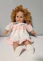 Full doll seated showing dress, hair, and face.