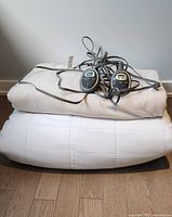 Stacked king-size heated blanket and mattress pad with controllers visible on top.