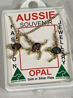 Complete set in original plastic display case showing necklace and earrings with opal inlays.