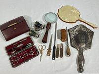 Overview of vintage self-care and personal items showing leather cases, grooming tools, hand mirrors, magnifying glass, and opera glasses.