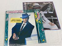 Two Elton John vinyl albums including Jump Up! and Greatest Hits, both sealed in plastic.