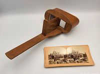 Wooden and brass PERFECSCOPE stereoscope viewer with the 1889 stereoview card placed in front.