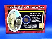 Front view of the collectible display featuring the 1935 Canadian one cent coin and the orange 1930-31 King George V stamp. The display card has detailed text about the coin and stamp specifications.