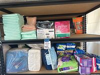 Shelf with stacked Depends adult underwear in light green packaging, Carefree and Always products, and a boxed Philips Respironics nebulizer.