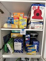 Overall cupboard with Dirt Devil vacuum boxes, Swiffer dusters packs, storage bags boxes and containers