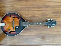 Top-down view of full mandolin showing sunburst finish, F-holes and black pickguard with pickup