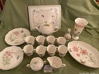 Full arrangement of Lenox Butterfly Meadow dinnerware including plates, cups, teapot, creamer, sugar set, Ansley vase, and placemats.