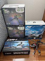 All boxed items and loose helicopter with batteries and charger arranged together on floor