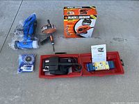 Photo of all four tools: Craftsman belt sander in red case, boxed Black & Decker mouse sander, Ridgid drain snake, and Grout Groovy cleaner with brushes.