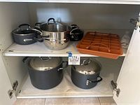 Two shelves of pots, brownie pan on top shelf