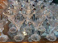 Multiple Mikasa Park Lane martini glasses arranged in rows showing flared bowl with vertical cuts and starburst base