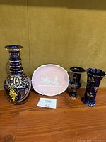Lot showing all items together: three cobalt blue and gold decorated vases and pink Wedgwood-style cameo dish