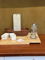 Overview of all items: bread warmer, wooden board, woven basket, butter dishes, honey container.