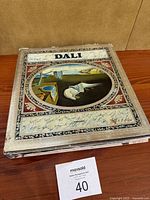 Front cover of hardcover Salvador Dalí art book published by Abrams showing The Persistence of Memory painting with visible wear and discoloration on the cover edges.