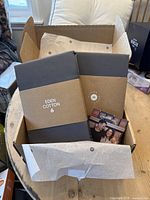 Box open displaying fitted sheet and two pillowcases wrapped in Eden Cotton branded paper and a thank you card included.