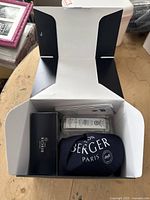 Open box displaying the Lampe Berger lamp wrapped in protective black cloth pouch and the Ocean Breeze fragrance oil in original packaging.