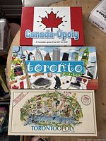 Three Canadian-themed Monopoly board games arranged in a stack: Canada-Opoly, Toronto in a Box, and Torontoopoly Collector's First Edition.