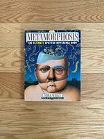 Front cover of the Metamorphosis book showing a surreal illustration with a human head and details describing it as a spot-the-difference book by Mike Wilks.