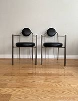 Front view of both chairs showing tubular metal frames and round cushions