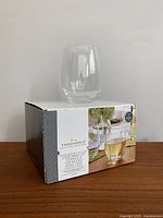 Set of four Threshold brand stemless wine glasses, boxed with one glass on top showing clear glass design.