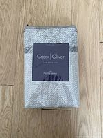 Photo of a sealed package containing one Oscar Oliver king size pillow sham measuring 20 x 36 inches, showing front label.