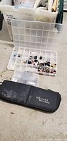 Image of black zippered Cultora Artist Marker case and clear plastic organizer box with small compartments holding buttons and craft embellishments.