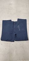 Folded men's dark blue pants with visible button and zipper area.